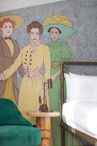 第比利斯The House Hotel Old Tbilisi的卧室配有一张床铺,并装饰有2位女性壁画。