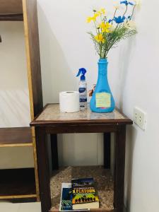 爱妮岛Queen's Room Rental 3的一张带蓝色花瓶和书籍的桌子
