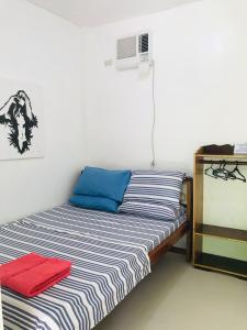 爱妮岛Queen's Room Rental 3的一间卧室配有一张蓝色和白色条纹的床