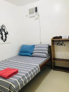 爱妮岛Queen's Room Rental 3的一张带蓝色和红色枕头的床