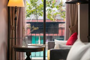 河内Hanoi Lion Boutique Hotel的带沙发、桌子和窗户的客厅