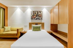 艾哈迈达巴德艾哈迈达巴德柠檬树酒店的配有一张床和一把椅子的酒店客房