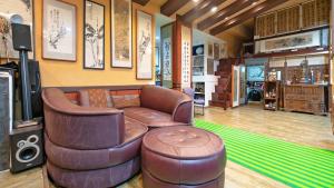 龙仁市Museum Stay的客厅配有真皮沙发和凳子