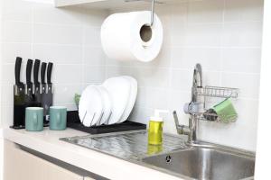 阿布扎比ZAPBED House - Luxury Holiday Homes in Yas Island的厨房柜台配有水槽和1卷纸质毛巾