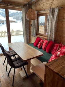 海因岑贝格Chaleny - Das erste Tiny House Chalet im Zillertal的客房配有一张床铺和一张带红色枕头的桌子。
