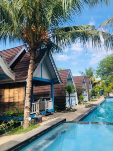吉利阿尔Youpy Bungalows的游泳池旁的棕榈树房子