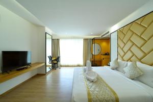 班加罗尔The President Hotel, kumarapark的一间酒店客房,配有一张大床和一台平面电视