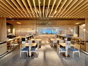 太原山西潇河新城温德姆酒店(潇河国际会议中心店)的餐厅设有木制天花板和桌椅