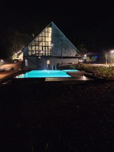 PadinjaratharaNammal Resorts的一座晚上设有游泳池的建筑