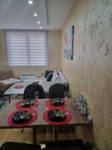 兹拉蒂博尔Apartman Stojanovic 2的一间带桌子和沙发的用餐室