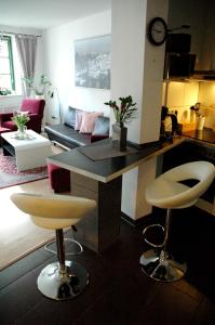 施特拉尔松德桑达帕特公寓的厨房以及带柜台和凳子的客厅。
