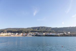 奥维塞多Apartagal-Mar de Vicedo的一大片水体,有一座城镇的背景