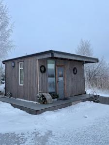 尤尔马拉Dzintarkrasts的雪中带门廊的小房子