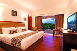库塔库塔帕拉迪索酒店的配有一张床和一台平面电视的酒店客房