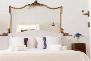 萨尔维Relais Carlo Alberto的白色的床、白色枕头和镜子
