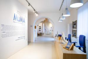 圣安蒂奥科MuMA Hostel的走廊上设有一张长桌子和蓝色的椅子