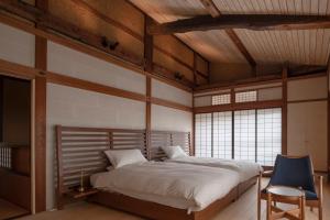 高山TANIYA的一间卧室配有一张大床和一张蓝色椅子