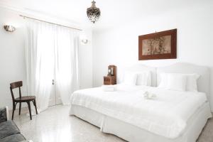 萨尔维Relais Carlo Alberto的白色卧室配有一张白色的大床和一把椅子