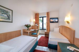 萨尔路易斯UNO Hotel Posthof Saarlouis的酒店客房配有两张床和一张书桌