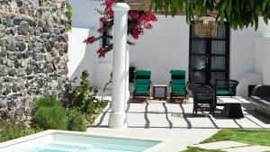 费拉Katikies Garden Santorini - The Leading Hotels Of The World的一个带椅子的庭院和一个游泳池