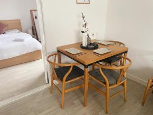 哥本哈根An cosy apartment near CPH airport的卧室里配有一张木桌和两把椅子