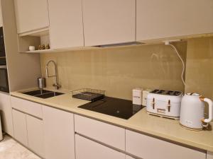 ColindaleSpacious 2 BR with Balcony in Hendon的厨房配有白色橱柜和台面