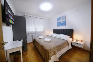 KriževciKalimero apartman A1的一间卧室配有一张床,上面有两条毛巾