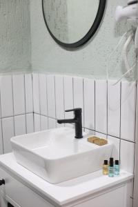 伯萨Mare House Boutique Hotel的浴室设有白色水槽和镜子