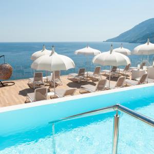马奥莱都耶托丽俱乐部酒店的一个带椅子和遮阳伞的游泳池