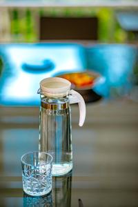 慕斯Chateau de Luxi Khao Yai - ชาโตว์ เดอ ลูซี่ เขาใหญ่的一瓶水和一张桌子上的玻璃杯