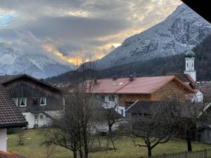 法尔先特Dachgeschosswohnung mit traumhaftem Zugspitzblick bei Garmisch的一座有教堂和山的村庄