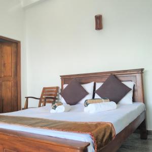 瓦都瓦Dhammika Beach Palace的一张带枕头的床和一把椅子