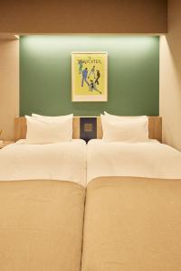 东京Section L Hatchobori的绿墙客房的两张床