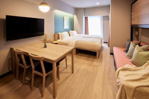 东京Section L Hatchobori的一间酒店客房,设有两张床、一张桌子和一台电视机
