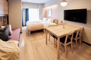 东京Section L Hatchobori的酒店客房设有一间卧室、一张桌子和一张床