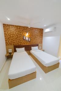 塞勒姆Sri K residency的一间卧室设有两张床和一堵墙