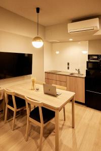 东京Section L Hatchobori的厨房配有木桌和笔记本电脑