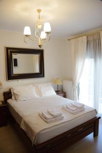 韦里亚Luxury Dafnis House的一间卧室配有带毛巾的床