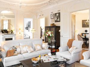 巴黎Hôtel Barrière Fouquet's Paris的客厅配有白色的沙发和桌子