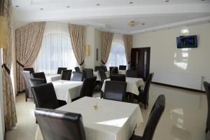布拉索夫A&N旅馆的用餐室配有白色桌子和黑色椅子