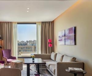 十月六日城Crowne Plaza - West Cairo Arkan, an IHG Hotel的带沙发和大窗户的客厅