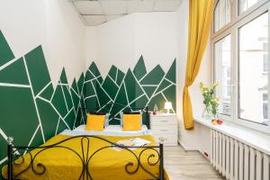 弗罗茨瓦夫Absynt Hostel Wrocław的一间卧室设有一张黄色的床,拥有绿色和白色的墙壁