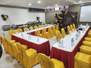 阿布贾Musada Luxury Hotels and Suites的一间会议室,配有桌子和黄色椅子