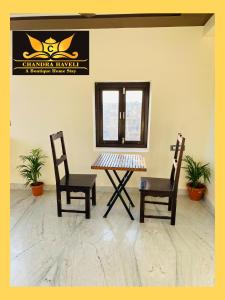 斋沙默尔Chandra Haveli Boutique Homestay的一张桌子、两把椅子和镜子