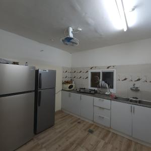 DawwahWadi Bani Khalid - Al Joud Green Hostel的厨房配有白色橱柜和冰箱。