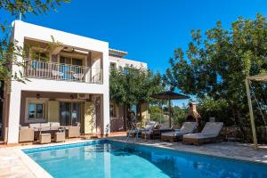 斯卡拉Astra Villas的别墅设有游泳池和庭院家具。
