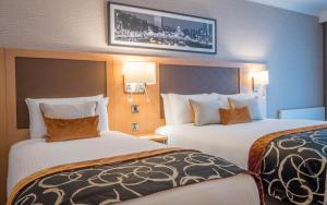 柯罗格伦都柏林机场克莱顿酒店的酒店客房设有两张床和一台墙上的电视。