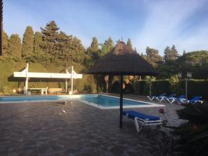 加的斯Villa Torrealta, 4000 m2, estancia mínima en verano 7 días de sábado a sábado的一个带遮阳伞和椅子的游泳池以及一个游泳池