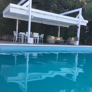 加的斯Villa Torrealta, 4000 m2, estancia mínima en verano 7 días de sábado a sábado的一个带桌椅的庭院和一个游泳池