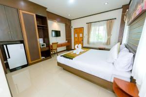 Phu KhieoBANDER HOTEL的卧室配有一张白色大床和一张书桌